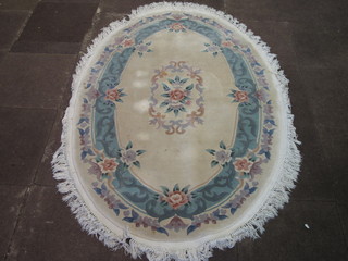 An oval cream ground and floral patterned Chinese carpet 72" x  48"