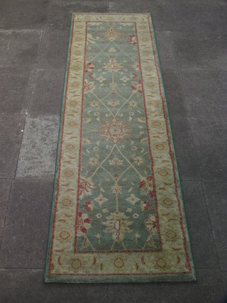 A machine made green ground and floral patterned runner 94" x 26"