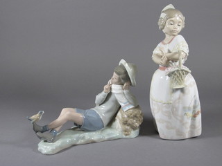 A Lladro figure of a reclining boy 8"- f and r and a Nao figure of  a standing lady with basket 9"