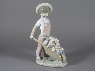 A Lladro figure of a standing boy with wheel barrow of flowers 9 1/2"