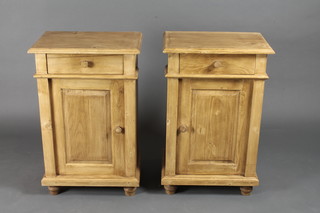 A pair of pine bedside cabinets fitted a drawer above double  cupboard, raised on bun feet 19"w x 13"d x 30"h