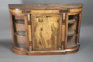 A Victorian inlaid figured walnut Credenza with gilt metal  mounts flanked by a pair of bow front cupboards enclosed by  glazed panelled doors, raised on a platform base 57"w x 14"d x  38"h  ILLUSTRATED