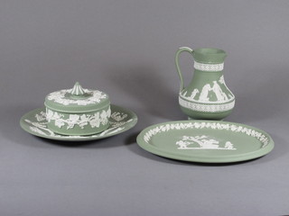 A Wedgwood green Jasperware jug 6", do. oval platter 9 1/2", do. plate 9" and a jar and cover 4 1/2"