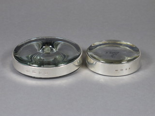 2 modern glass paperweights with silver rims 3" and 3 1/2"