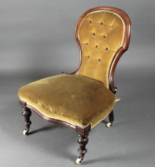 A Victorian mahogany show frame nursing chair upholstered in  yellow material, raised on turned supports