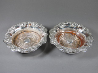 A pair of silver plated bottle coasters with cast vinery decoration