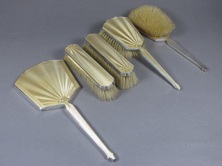 An Art Deco 5 piece silver and yellow enamelled backed dressing  table set comprising hand mirror, pair of hair brushes, pair of  clothes brushes, Birmingham 1938