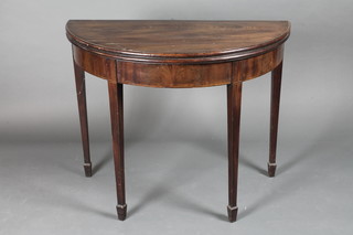 A Georgian mahogany demi-lune tea table, raised on square tapering supports ending in spade feet 36"w x 17 1/2"d x 29"