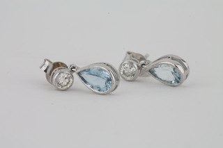 A pair of tear drop shaped earrings set a diamond and  aquamarine