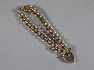 A gold curb link bracelet with padlock clasp