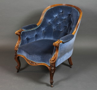 A Victorian mahogany show frame armchair upholstered in blue material, raised on cabriole supports