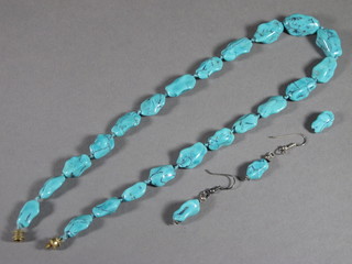 A turquoise necklace and a pair of turquoise earrings