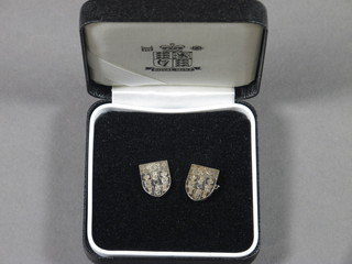 A pair of silver cufflinks decorated coat of arms