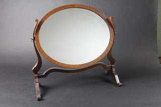 An oval plate dressing table mirror contained in a mahogany  swing frame 19"