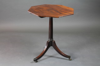 A 19th Century octagonal mahogany wine table raised on a gun  barrel turned column with triform base ending in brass caps and  castors 24"w x 29"h