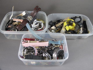 3 small plastic boxes containing a collection of various  wristwatches