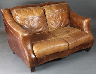 A two seat sofa upholstered in brown leather 59"w x 36"d x 34"h