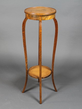 A circular honey oak 2 tier jardiniere stand raised on cabriole supports 12" x 39"