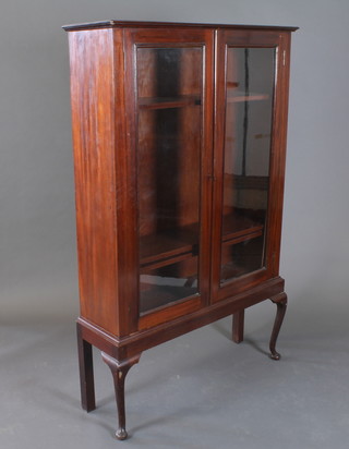 A mahogany bookcase fitted adjustable shelves enclosed by glazed panelled doors, raised on cabriole supports 40"w x 12"d x  63"h