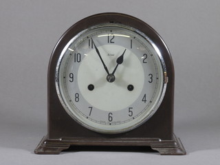 An Art Deco striking mantel clock with silvered dial and Arabic numerals contained in an arched brown Bakelite case
