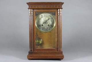 A striking mantel clock with silvered dial and Arabic numerals contained in an oak case