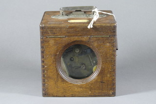 A chrome pigeon clock contained in an oak carrying case