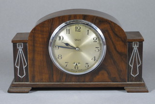A Smiths Art Deco electric bedroom clock with silvered dial and Arabic numerals contained in a walnut arch shaped case