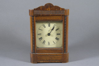 A Continental alarm clock with paper dial and Roman numerals contained in an oak case