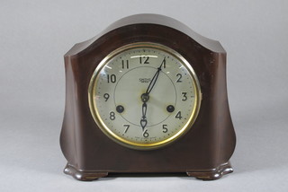 A striking mantel clock with silvered dial and Arabic numerals contained in an arch shaped Bakelite case