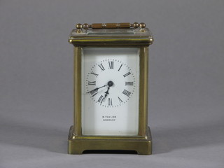 A carriage clock with enamelled dial and Roman numerals  contained in a gilt metal case marked R Taylor Bromley