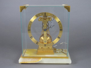 A skeleton clock contained in a gilt metal case