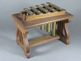 An oak and brass xylophone dinner gong, raised on an oak base with lyre supports 14"