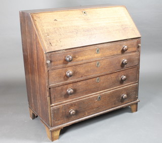 A Georgian oak bureau the fall front revealing a well fitted  interior above 4 long drawers with tore handles, raised on bracket  feet 39"w x 20"d x 42"h