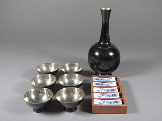 An Oriental club shaped Saki decanter together with 6 cups and 5 porcelain chop stick rests