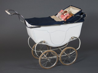 A childs Triang pram containing 2 plastic dolls