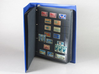 A blue loose leaf album of various world stamps