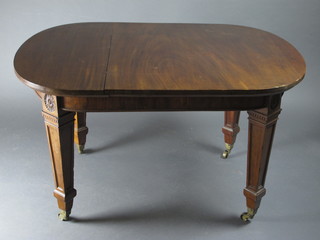 An Edwardian oval mahogany dining table raised on square tapering supports ending in brass caps and castors 51"w x 36"d x  29"