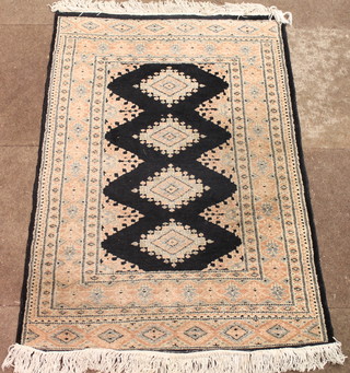 A Pakistan hand knotted black ground rug with 4 octagons to the  centre 47" x 31"