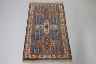 A brown and blue ground Eastern rug with 3 stylised octagons to the centre 51" x 30"