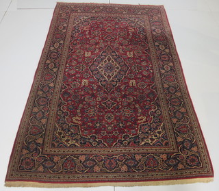 A fine quality red and floral patterned Persian carpet with central medallion within multi-row borders 89" x 52"