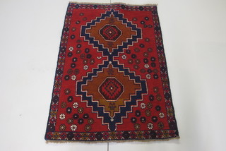 A contemporary Persian Balochi red ground wool carpet with 2  blue octagons to the centre 54" x 35"