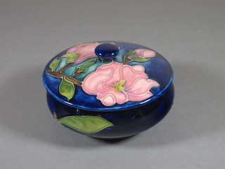 A Moorcroft blue glazed jar and cover decorated pink magnolia,  base impressed Moorcroft, circa 1980's 4"