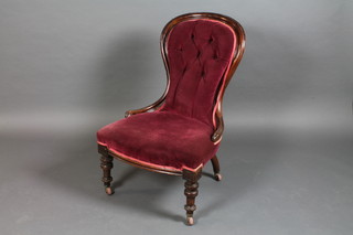 A Victorian mahogany show frame chair upholstered in buttoned material raised on turned supports