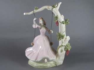 A pottery figure of a lady on a swing 13", a Royal Crown Devon  blue glazed vase with gilt decoration 7" and a Royal Crown  Devon red glazed ginger jar and cover 4"