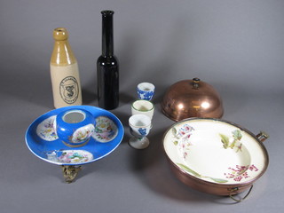 A circular pottery childs warming plate with copper liner - chipped, 3 decorative egg cups, a J T Shardlow ginger beer  bottle, a brown glass club shaped bottle and a Sevres style  circular porcelain ink well - f, no lid,