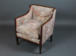 An Edwardian mahogany show frame armchair upholstered in  floral material on square tapering supports