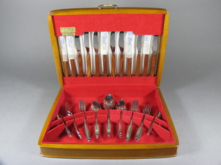 A canteen of stainless steel flatware contained in a teak canteen  box