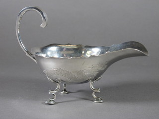 An Eastern engraved white metal sauce boat decorated a dragon