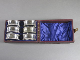 A matched set of 6 silver plated napkin rings, cased
