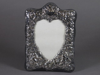 A modern embossed silver heart shaped easel photograph frame,  8"